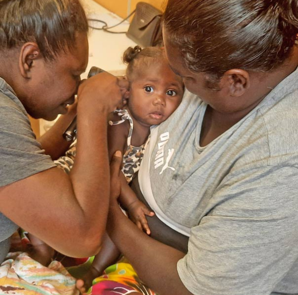 Aboriginal child having her ear checked.
