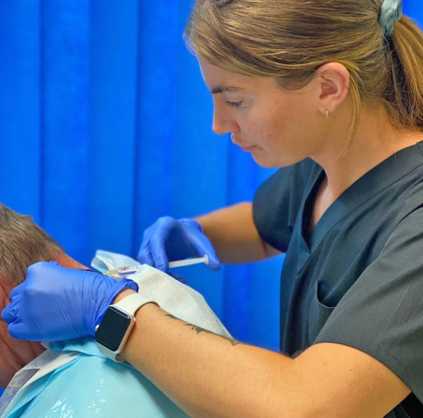 Nurse Lauren from Skin Patrol prepping a patient for surgery. Outreach provider, Dr Tim Bainbridge-Brown and Nurse Lauren from Skin Patrol undertaking surgery to remove a skin cancer.