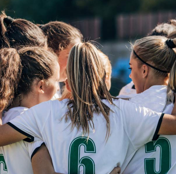 Women's sporting team hugging