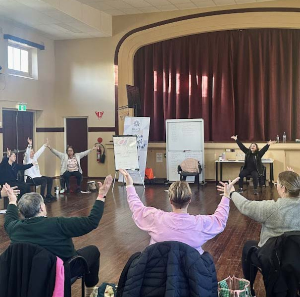 People seated in a community hall having a dance session