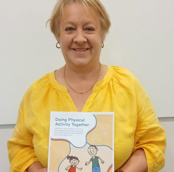 Mrs Julie Rafter holding the resource Doing Physical Activity Together