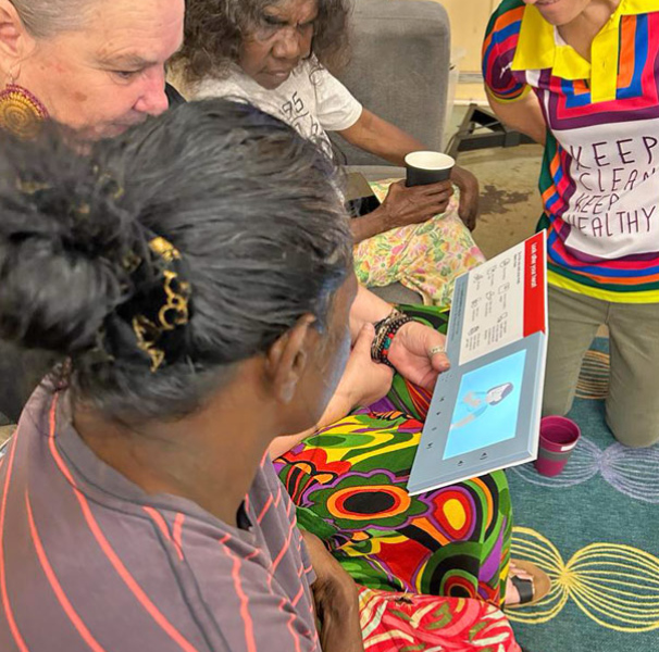 Vicki Wade (centre) sharing a sound book with participants. 